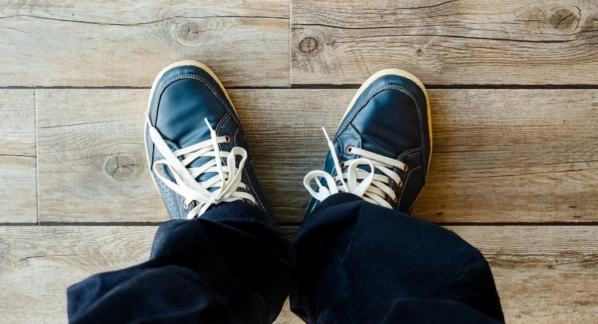 スニーカーを履いた人の足元を上から撮影した写真