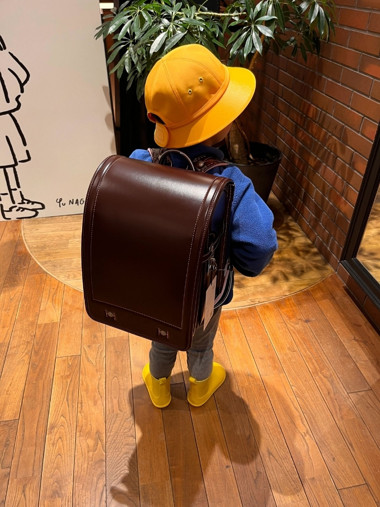 ダークブラウンのランドセルを背負った息子さんの写真
