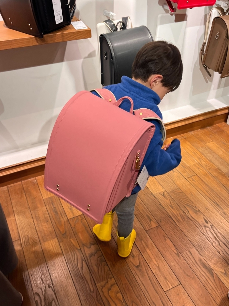 サーモンピンクのランドセルを背負った息子さんの写真
