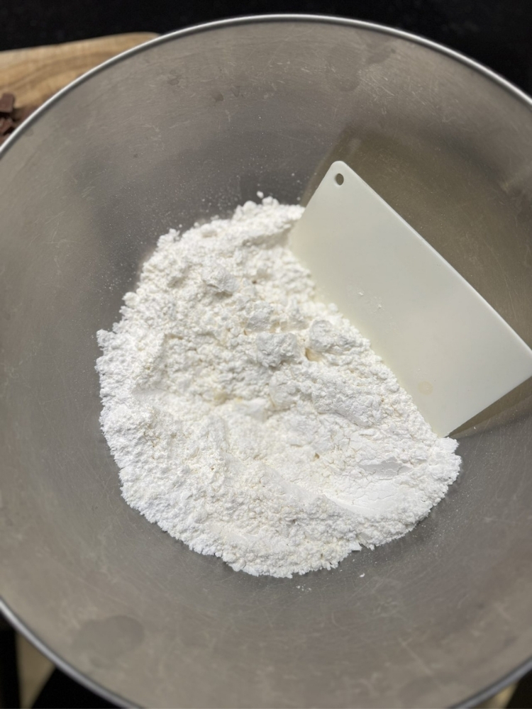 ボウルに入ったスクレイパーと粉の写真