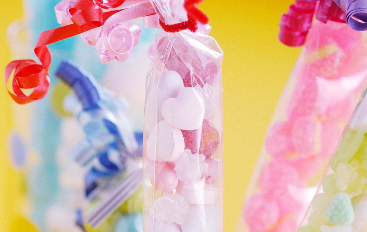 リボンラッピングされたカラフルな袋詰めお菓子の写真